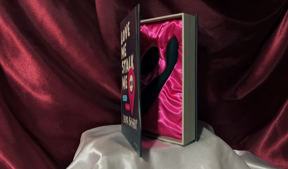 A half opened book box presenting Callahan with its remote, the official adult toy from the dark romance book Love Me Stalk Me by Laura Bishop.