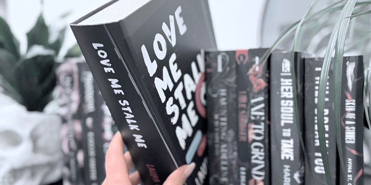 A hand holding the Callahan book styled package for the toy of the dark romance book Love Me Stalk Me by Laura Bishop.