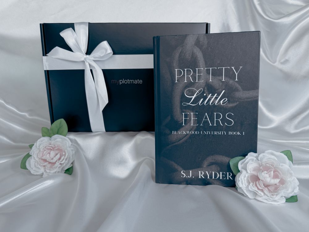 The book Pretty Little Fears by S.J. Ryder in front of a myplotmate box with a white ribbon and two roses next to it.