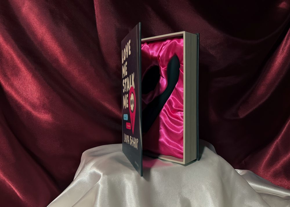 A half opened book box presenting Callahan with its remote, the official adult toy from the dark romance book Love Me Stalk Me by Laura Bishop.