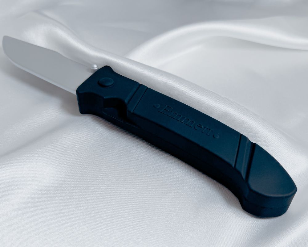 A dark romance adult toy called Emmett, that is a silicone knife with a silver blade and black hilt.