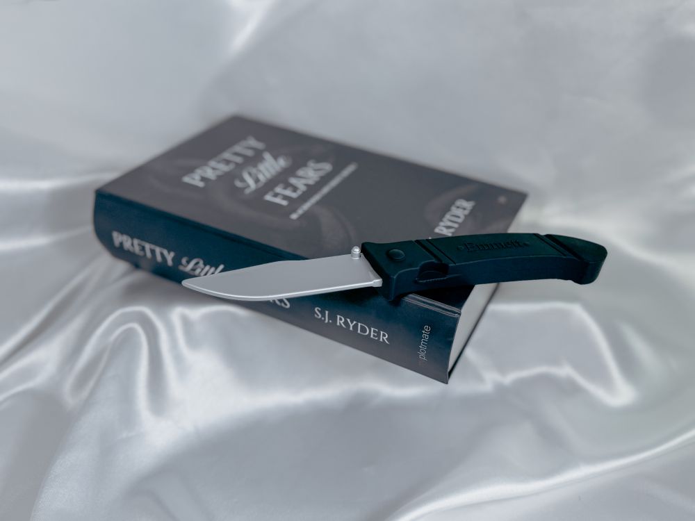 The silicone knife toy for Pretty Little Fears by S.J. Ryder on its book-like package.