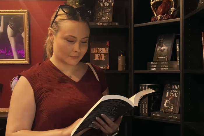 myplotmate founder reading a dark romance book.